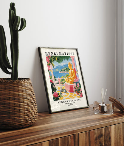 Framed art print showing golden Buddha with cat, flowers, and ocean backdrop